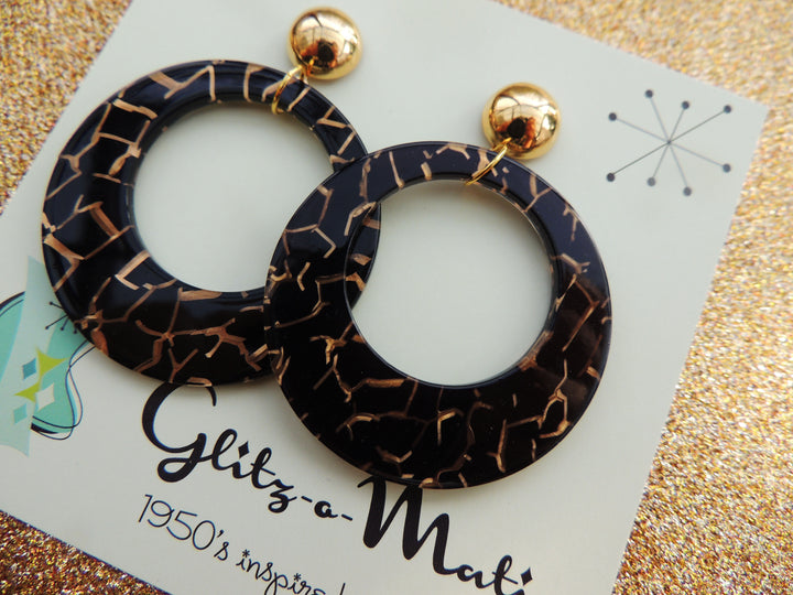 Glitz-o-Matic – Boucles d'oreilles en lucite noires et dorées